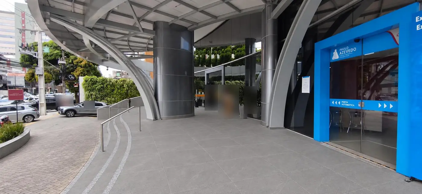 Visualização realista da entrada do edifício, com piso em porcelanato cinza e faixas de granito nos degraus