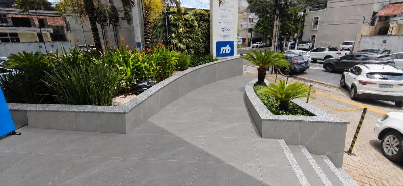 Visualização realista: rampa e floreiras revestidas em porcelanato cinza, com topos em granito